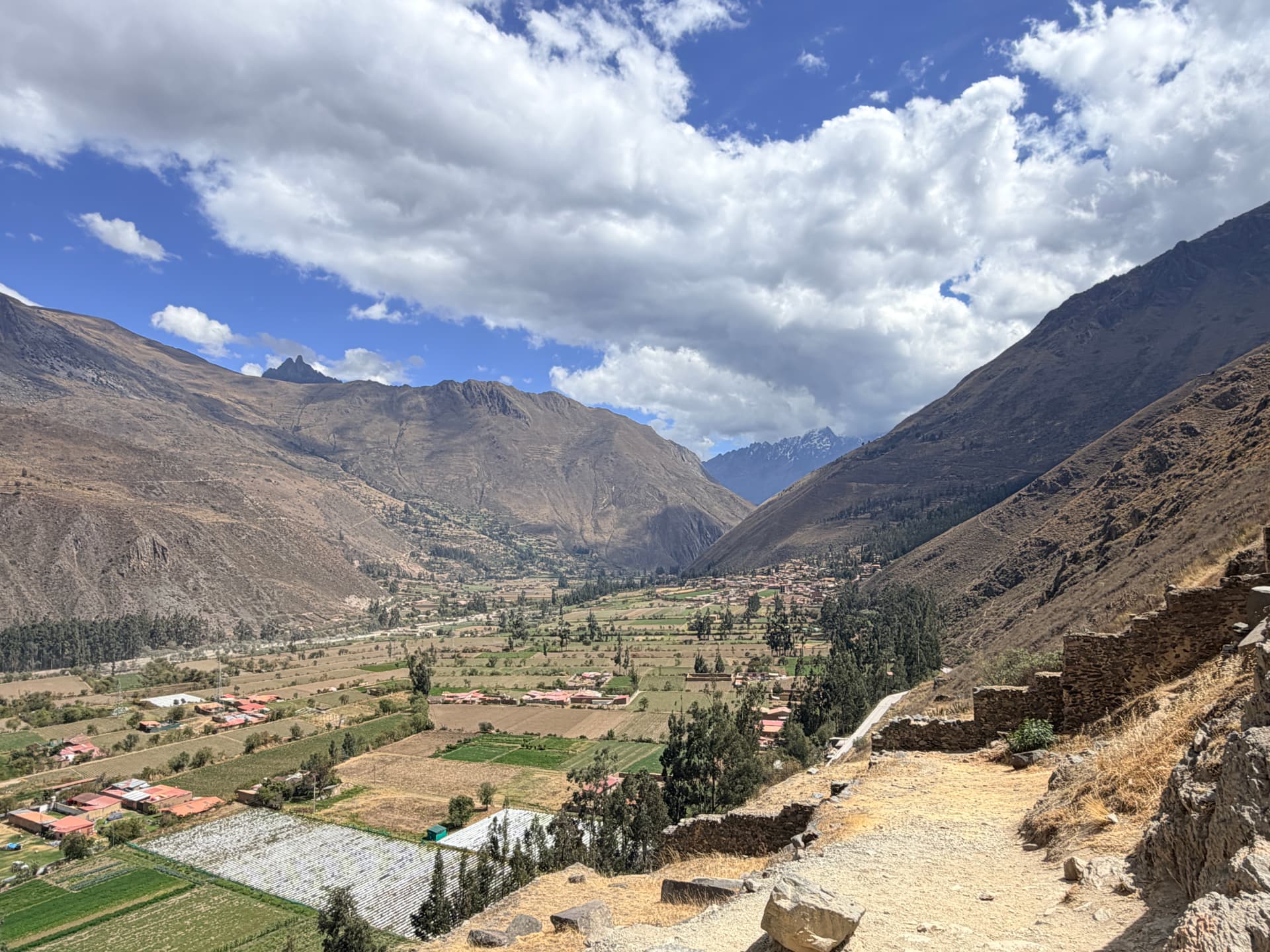 View down the Sacred Valley from Ollantaytambo with farm fields and snowy peaks