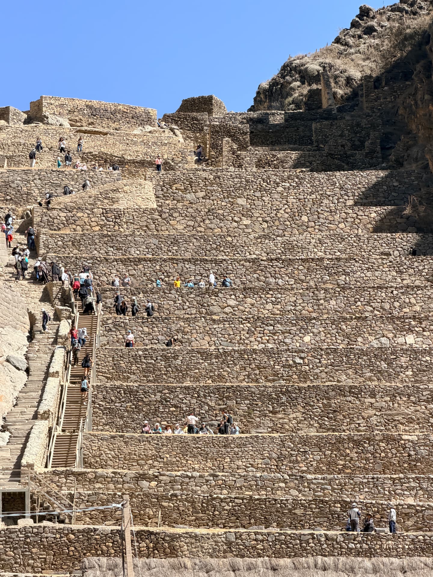Visitors climbing the great stone terraces of the Ollantaytambo fortress