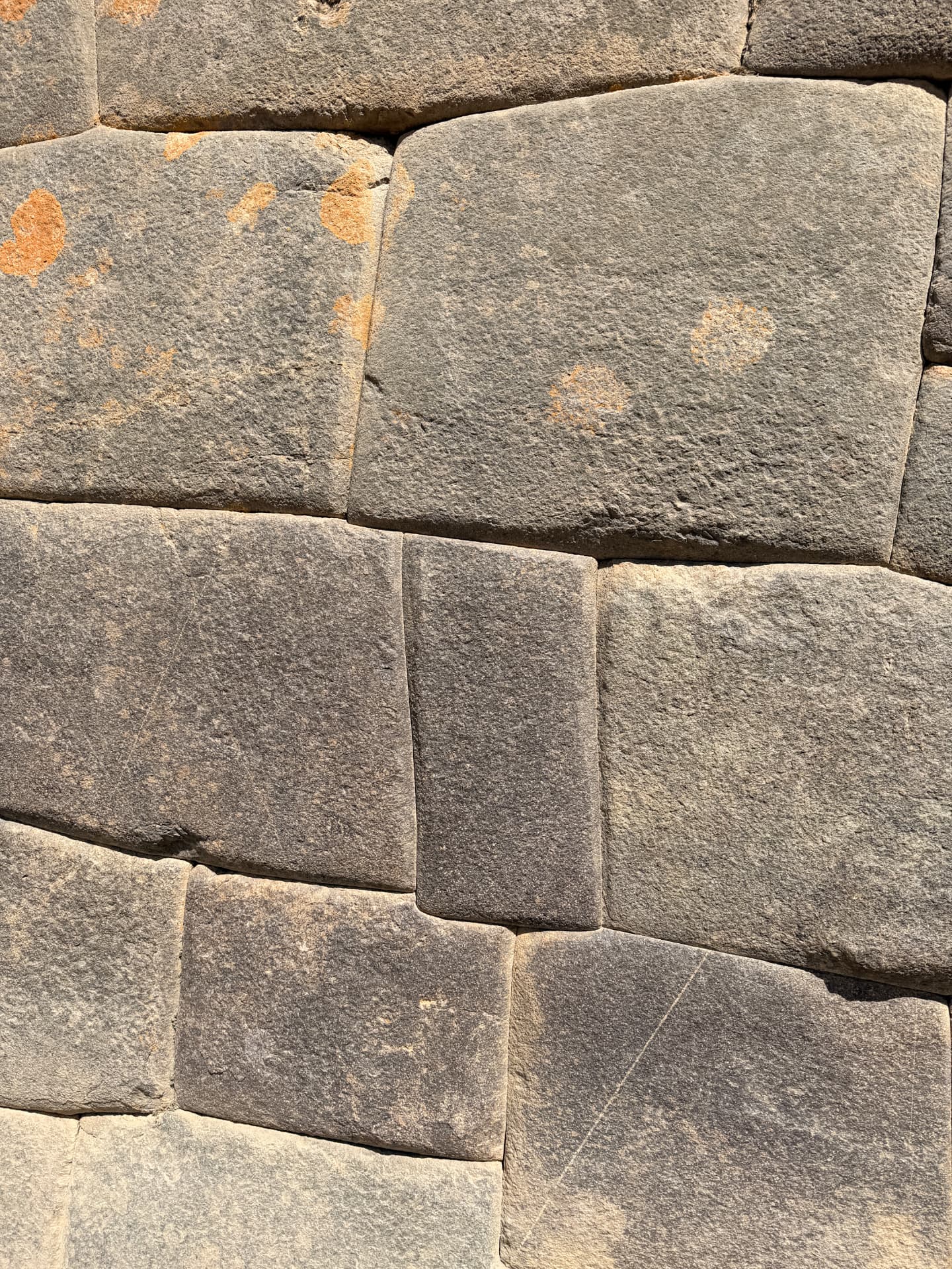 Close-up of tightly fitted Inca stonework with lichen on the granite blocks